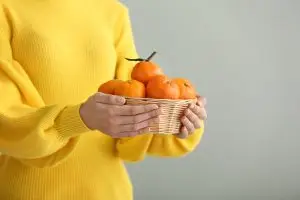 Woman holding basket of clementines
