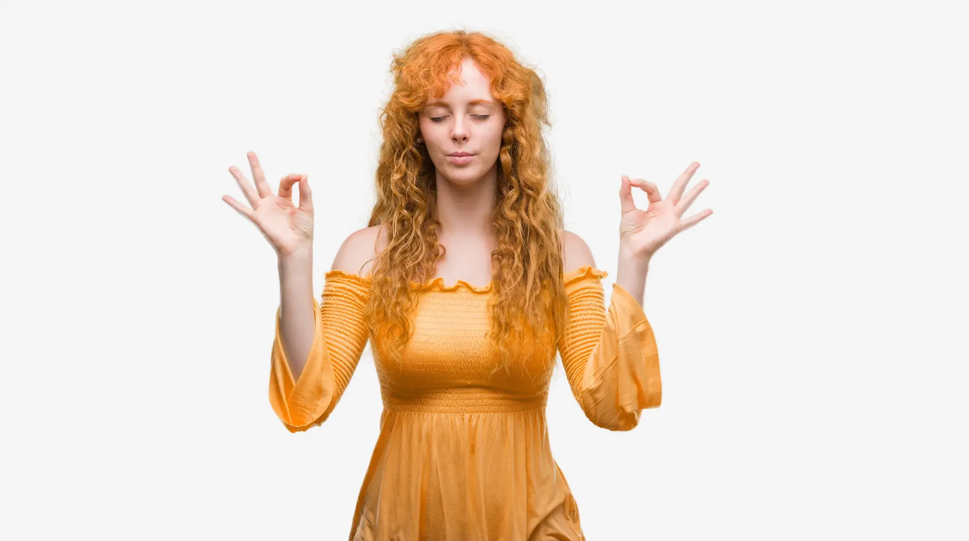 Young redhead woman in orange dress relaxed and smiling with eyes closed doing meditation gesture with fingers.