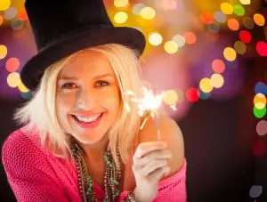 Woman with top hat waving magic wand.